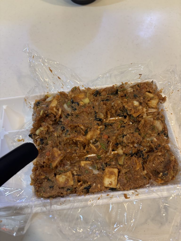 製氷皿にラップを敷いて味噌玉を詰めたところ